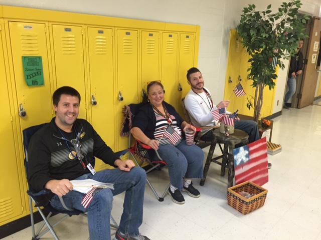 Mr. Kubik, Mrs. Ursiny, and Mr. Facchin enjoy a rest while monitoring the hall. For these teachers, Front Porch Friday has become a way to have fun and build community.